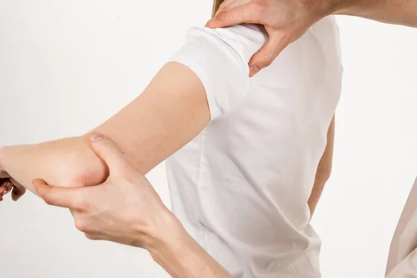 Movement assessment or shoulder joint mobilization. Muscle release. Orthopedic traumatologist examines shoulder joint of patient and checks mobility of movements on white background