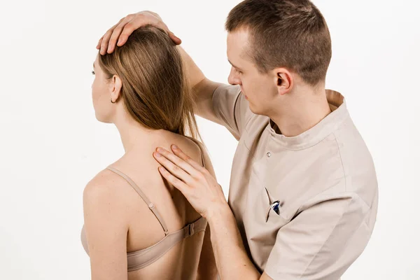 Manual therapy at physiotherapist or chiropractor. Orthopedist examining female neck and head. Manual correction of the ridge and cervical region. Rehabilitation therapy on white background
