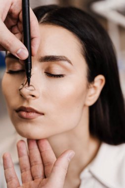 Burun kaplamalı burun kapağı. Burun cerrahisi burun ameliyatını yeniden şekillendiriyor. KBB doktoru burun ameliyatından önce burnuna çizgiler çiziyor.