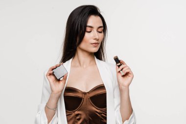 Makyöz kız, dudaklarını beyaza boyamak için elinde ruj tutuyor.