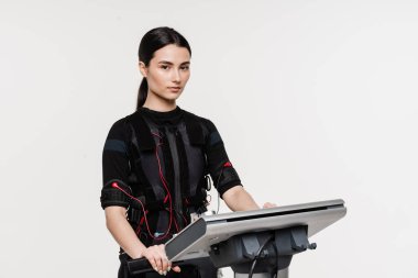 Beyaz arka planda EMS kıyafetli kız. Elektrik kas stimülasyonu giysisinde spor eğitimi