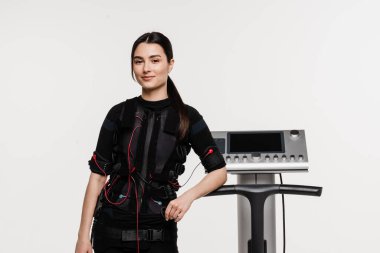 Beyaz arka planda EMS kıyafetli kız. Elektrik kas stimülasyonu giysisinde spor eğitimi