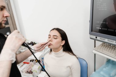 ENT uzmanları gırtlak ve gırtlak, gırtlak düğümleri, ses teli nodülleri, tümörler, enfeksiyonlar ve iltihaplanma gibi hastalıkları teşhis eder ve tedavi eder. KBB doktoru burnunu incelemek ve tedavi etmek için fibrolaryngoskop kullanıyor.