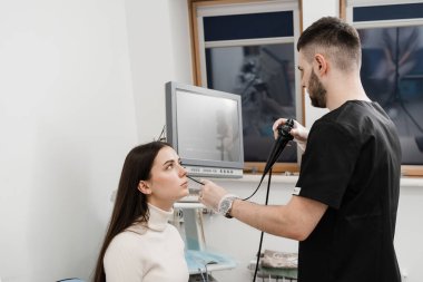 KBB doktoru kulakları incelemek ve tedavi etmek için fibrolaryngoskop kullanıyor. ENT uzmanları gırtlak ve gırtlak, gırtlak düğümleri, ses teli nodülleri, tümörler, enfeksiyonlar ve iltihaplanma gibi hastalıkları teşhis eder ve tedavi eder.