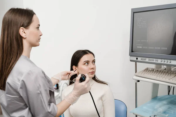 ENT doctor using fibrolaryngoscope to examine and treat the ears. ENT specialist diagnoses and treats larynx and pharynx, such as hoarseness, vocal cord nodules, tumors, infections, and inflammation