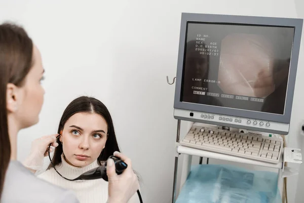 ENT doctor using fibrolaryngoscope to examine and treat the ears. ENT specialist diagnoses and treats larynx and pharynx, such as hoarseness, vocal cord nodules, tumors, infections, and inflammation