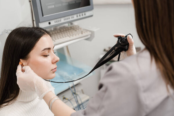 Fibrolaryngoscope for diagnose and treat larynx and pharynx, such as hoarseness, vocal cord nodules, tumors, infections, and inflammation. ENT doctor with flexible fibrolaryngoscope