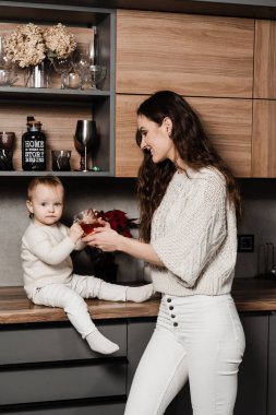 Anne ve kız çocuğu mutfakta bir fincan çay içiyorlar. Doğumhane. Mon ve oğlu evde birlikte vakit geçiriyorlar.