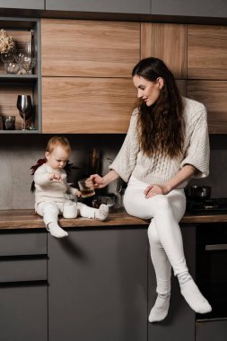 Anne ve kız çocuğu mutfakta bir fincan çay içiyorlar. Doğumhane. Mon ve oğlu evde birlikte vakit geçiriyorlar.