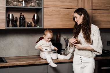 Anne ve kız çocuğu mutfakta bir fincan çay içiyorlar. Doğumhane. Mon ve oğlu evde birlikte vakit geçiriyorlar.