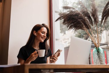 Kendine güvenen iş kadını bilgisayarını kullanarak video bağlantısı kuruyor ve yeni fikirleri tartışıyor. Bilgisayarlı mutlu kız, arkadaşları ve ailesiyle kafede sohbet ediyor.