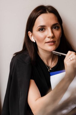 Mesafe öğrenme. Kafede kitabı olan neşeli bir kız. Konsantre İngilizce öğretmeni video iletişimi yoluyla çevrimiçi dersten önce notlar yazar