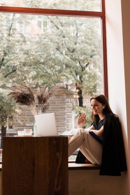 Diz üstü bilgisayarı olan zeki bir öğrenci Kafe 'deki dil okulunda İngilizce okuyor. Çekici genç kadın öğretmeniyle video iletişimi dersi alıyor.