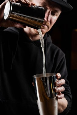 Barmen barda penisilin kokteyli hazırlıyor ve karıştırıyor. Barmen viski, limon suyu ve zencefil şurubunu karıştırarak penisilin alkollü kokteylini hazırlıyor.