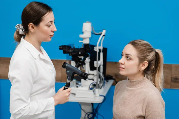 stock image Ophthalmoscopy. Consultation with optometrist in medical clinic. Ophthalmologist examines the eyes of woman with ophthalmoscope. Ophthalmology