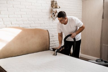 Kuru temizlemeci, lekeleri ve yataktan kiri çıkarmak için çıkartma makinesi kullanıyor. Kuru temizleme makinesi evdeki döşeklere su ve deterjan püskürtüyor.