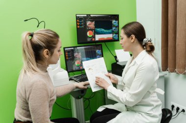 Göz arkası görüntülerini oluşturmak için optik tutarlılık tomografisi tomografisi ile optometriste danışma. Optik tutarlılık tomografisi kullanan hastanın gözlerinin incelenmesi