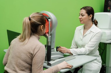 Korneanın şekli ve gücünün görsel tanımı için kornea topografisi göz görme testi. Kornea topografının kırmızı ışığı topoğrafya sınavında kadının üzerine parlıyor