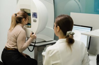Göz perimetri testi, göz hastalıkları kliniğindeki kadının glokom belirtilerini gösteriyor. Kenar ya da çevresel görüş dahil olmak üzere tüm görüş alanlarını ölçmek için perimetri görsel alan testi