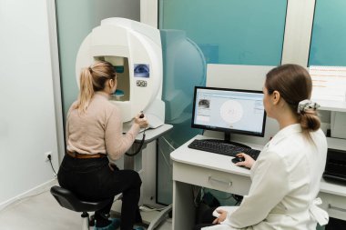 Yan ve çevresel görüş dahil olmak üzere tüm görüş alanlarını ölçmek için perimetri görsel alan testi. Göz perimetri testi, göz hastalıkları kliniğindeki kadının glokom belirtilerini gösteriyor.