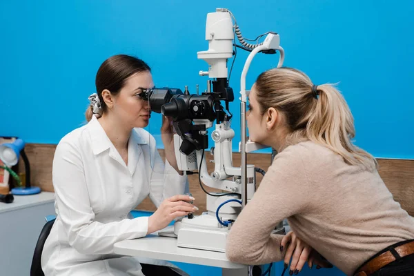 眼科医生用缝隙灯检查妇女的眼睛和角膜 眼科医生用裂隙灯照射病人的眼睛 以诊断眼睛和角膜 — 图库照片