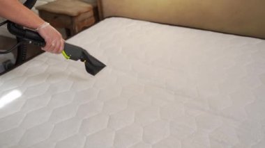 4K video kuru temizlemeci kuru temizleme makinesiyle yataktan toz ve toz kaldırıyor. Çekme suyu ve kuru temizleme makinesinin deterjanı.