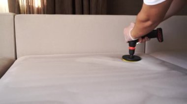 4K video ev içi kuru temizleme için kanepeye deterjan uyguluyor. Deterjanı kanepeye sürterek kuru temizleme için fırçayla delmek