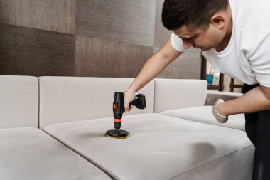 Kuru temizleme için evdeki kanepeye deterjan sürüyorum. Deterjanı kanepeye sürterek kuru temizleme için fırçayla delmek