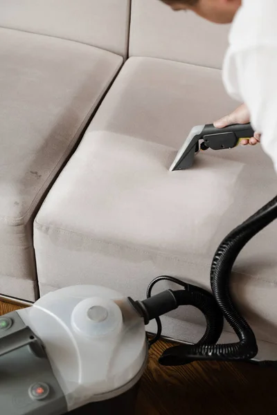 Line on couch after dry cleaning with washing vacuum cleaner extractor machine. Domestic cleaning service cleaner is removing dirt and dust from couch using dry cleaning extraction machine