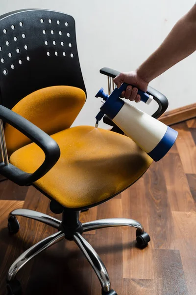 家のアームチェアから汚れや汚れを除去するための乾燥洗浄のプロセス プロのクリーニングサービス 洗浄真空クリーナー抽出機を使用して乾燥洗浄のための椅子に洗剤を噴霧 — ストック写真