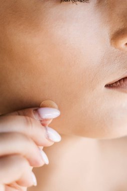 Kızın yanağında sivilce bandı var. Sivilce ve rosacea tedavisi için sivilce bandı kullanan genç bir kadın. Yüz gençleştirme, kozmetolojiyi temizleme.