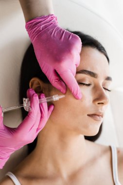 Elmacık kemiklerine hiyalüronik asit enjekte edilmiş. Elmacık kemiklerinin hacmini ve şeklini düzeltmek için plastik kontur