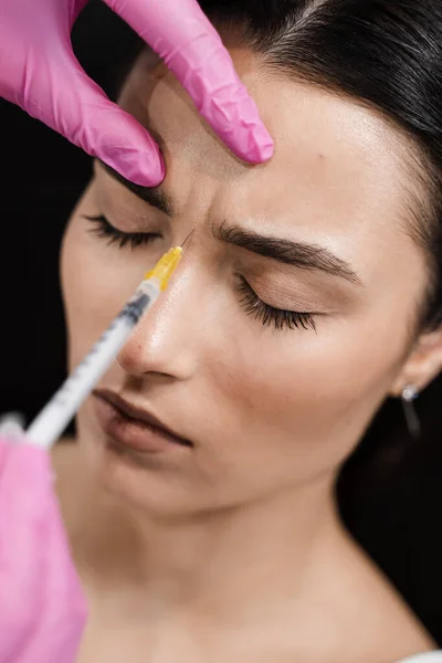 Beautician is injecting botulinum toxin to correct mimic wrinkles and hyperhidrosis for young girl. Botulinum toxin to relax and neutralize overactive muscles that cause wrinkles