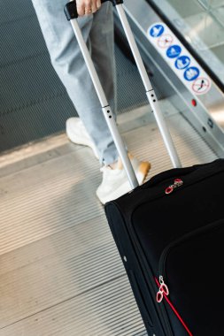 Seyahat valizi havaalanı lobisinde. Bir kadın mavi seyahat çantasıyla gezintiye çıkıyor. Seyahat ve tatil kavramı