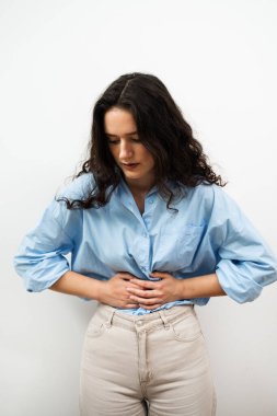 Gastrit, genç bir kadının midesinde oluşan iltihaplanma. Çekici kız mide ülseri yüzünden karnına dokunuyor.