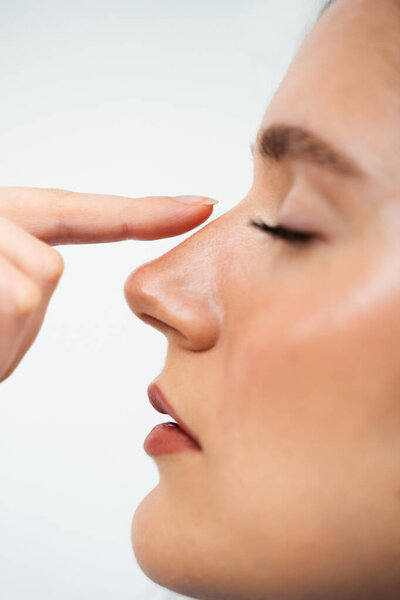 Close-Up Rhinoplasty To Reshape The Nose And Improve Breathing. Attractive Girl Touches Her Nose Before Septoplasty
