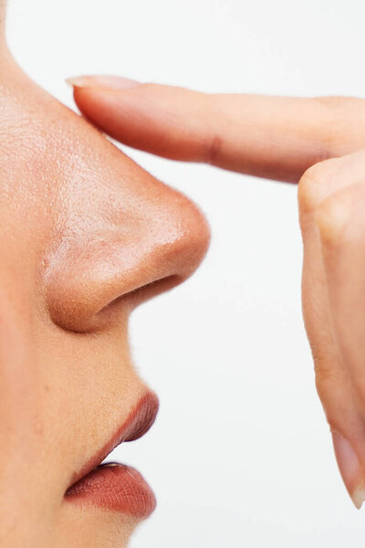 Close-Up Rhinoplasty To Reshape The Nose And Improve Breathing. Attractive Girl Touches Her Nose Before Septoplasty