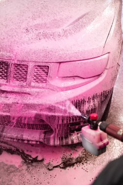 Otomobil yıkama istasyonunda araba yıkarken pembe köpüklü deterjan sürüyorum. El temizliği.