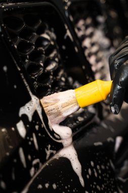 Araba yıkama fırça kullanma ve köpük sürme. Araba yıkamada oto yıkama. Arabanın yıkama elementlerini yumuşak fırça ve temizleyici köpük kullanarak kapat