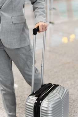 Havaalanındaki bagaj görüntülerini kapat. Bir yolcu el ele tutuşup havaalanı lobisine bavul çekiyor.