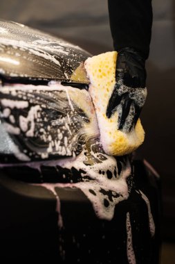 Otomobil yıkamada yıkanan el yapımı bir araç. Sünger ve deterjan kullanarak far temizleme işlemi