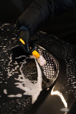 Araba yıkama fırça kullanma ve köpük sürme. Araba yıkamada oto yıkama. Arabanın yıkama elementlerini yumuşak fırça ve temizleyici köpük kullanarak kapat