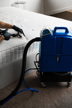 Temizlikçi evdeki leke, toz ve kiri temizleme makinesiyle temizliyor. Kanepe yastıklarını sökücüyle kuru temizleme.
