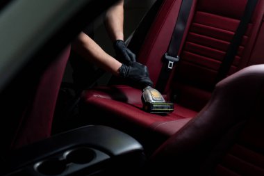 Özel elektrikli süpürgeyle oto koltukları detaylandırmak. Araba koltukları turbo fırça başlığıyla süpürülüyor.
