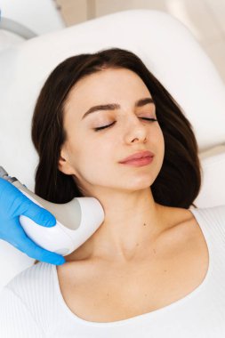 Donanım kozmetoloji prosedürü. İğnelerden arınmış rf kaldırma işlemi. Enjeksiyon olmadan yüz şeklinizi sıkmanız gerektiğinde.