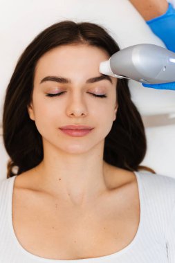 Çekici bir kız kozmetoloji kliniğinde yüz gerdirme ameliyatı oluyor. Ultraformer cerrahi olmayan yüz gerdirme işlemi