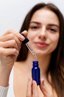 Çekici kız pipeti hyaluronik asit sıvısıyla dolduruyor. Kozmetik biliminden sonra yüz derisinin yenilenmesi, hyaluronik asit tabakasının yardımıyla gerçekleşir.