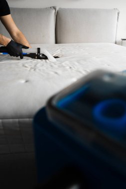 Mattress cleaning with extractor at home. Dry cleaning with extractor to get rid of stains, dust and dirt on house furniture clipart