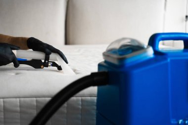 Temizlikçi evdeki leke, toz ve kiri temizleme makinesiyle temizliyor. Kanepe yastıklarını sökücüyle kuru temizleme.