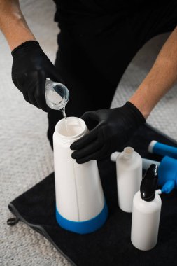 Çıkarıcı ve oksijen temizleyici deterjan ile etkili temizlik. Temizlikçi döşeme mobilyalarını temizlemek için oksijen temizleyici sıvı kullanıyor.